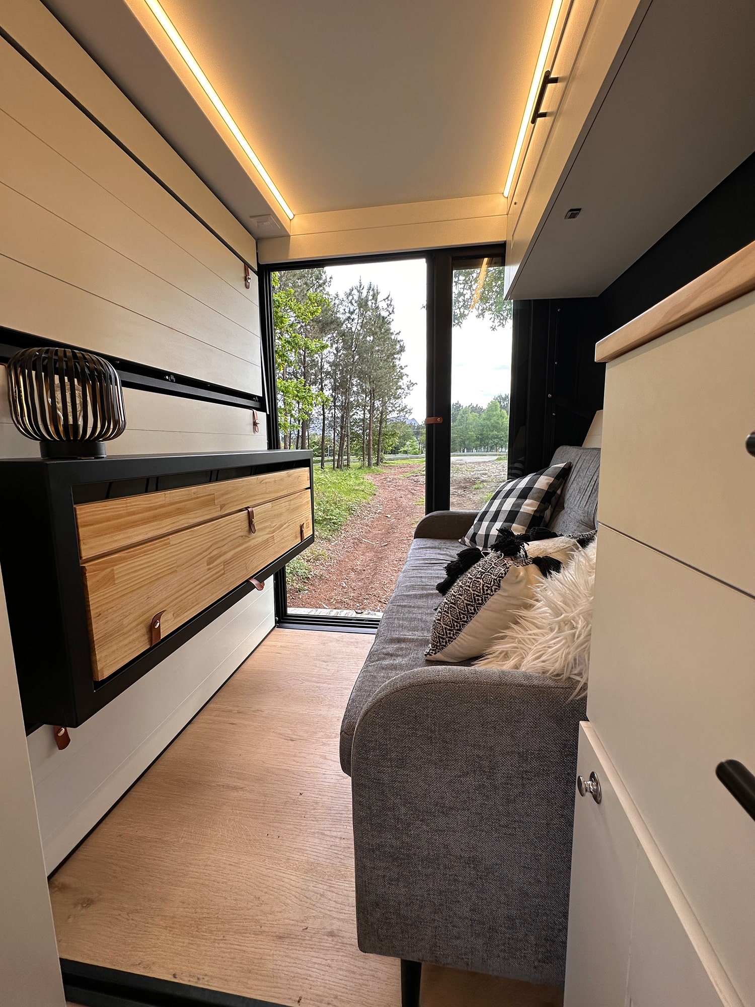 Salón de un módulo camper Vancubic con sofá y muebles de almacenamiento